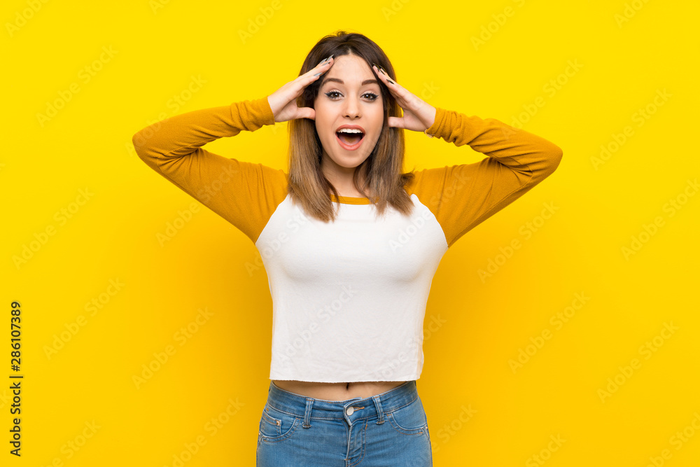 Pretty young woman over isolated yellow wall with surprise expression Pretty young woman over isolated yellow wall with surprise expression