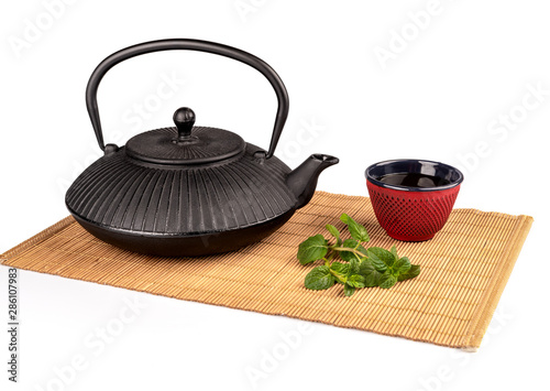 Japanese teapot isolated on bamboo mat