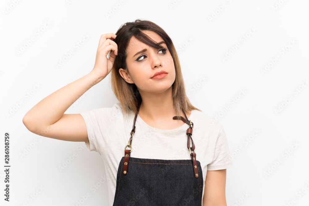 Young woman with an apron having doubts and with confuse face expression Young woman with an apron having doubts and with confuse face expression