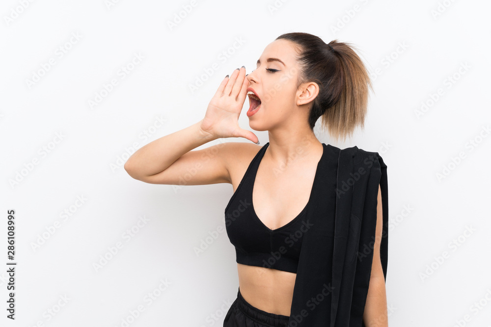 Young sport woman over white wall shouting with mouth wide open Young sport woman over white wall shouting with mouth wide open