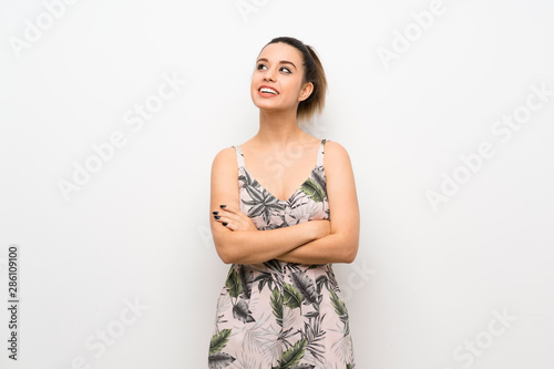 Young woman over isolated white background looking up while smiling © luismolinero