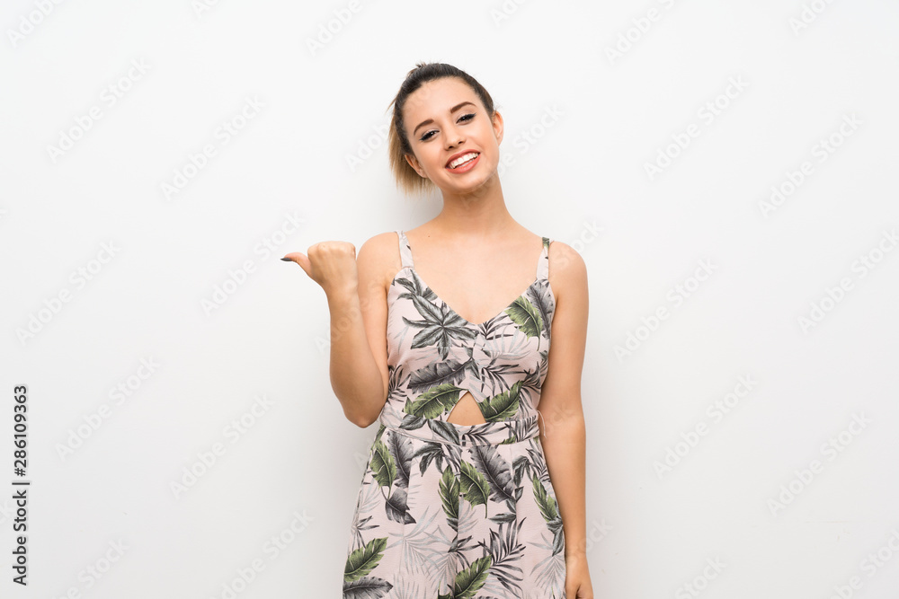 Young woman over isolated white background pointing to the side to present a product Young woman over isolated white background pointing to the side to present a product