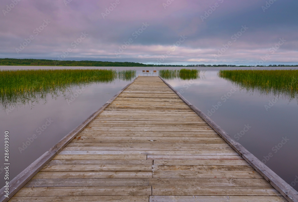 Idyllic view of the wooden pier in the lake with chairs for negotiations Idyllic view of the wooden pier in the lake with chairs for negotiations