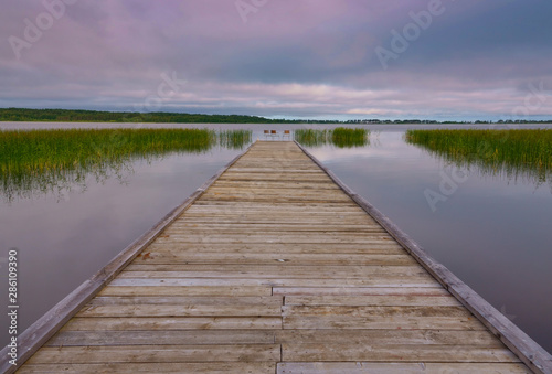 Idyllic view of the wooden pier in the lake with chairs for negotiations
