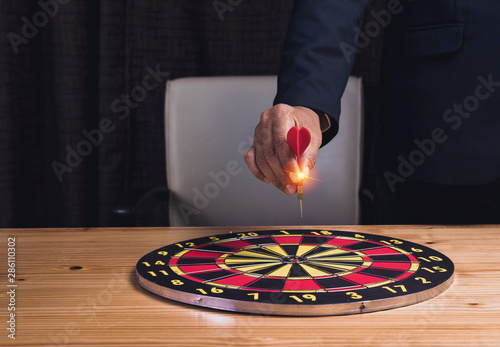 Asian businessman hand hold red arrowon at home office desk background.,targeting the business concept. photo