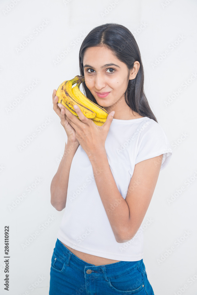 Young asian girl holding ripe fresh organic yellow banana Isolated on white background, fresh fruits and health concept - Image Young asian girl holding ripe fresh organic yellow banana Isolated on white background, fresh fruits and health concept - Image