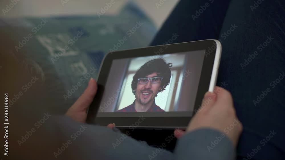 Man and woman communicate through video chat on tablet Man and woman communicate through video chat on tablet