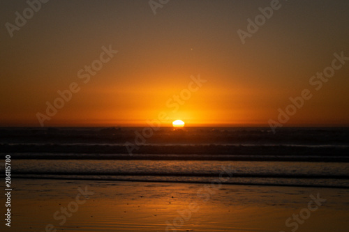 Last sunlight of the day with sunset over the Atlantic Ocean from Agadir beach, Morocco, Africa