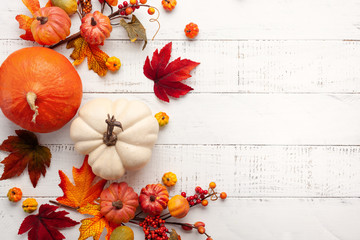 Festive autumn decor from pumpkins, berries and leaves on a white  wooden background. Concept of Thanksgiving day or Halloween. Flat lay autumn composition with copy space.