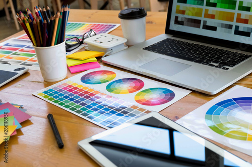 Close up object creative designs concept. Creative designs workplace with laptop, table, pencil color and color bar example on the table.