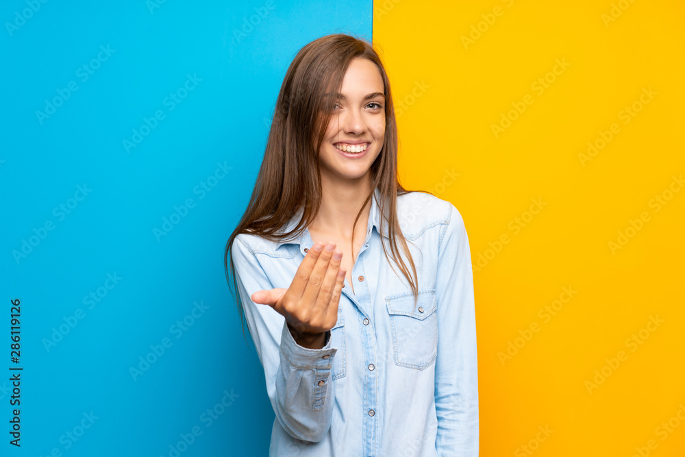 Young woman over colorful background inviting to come