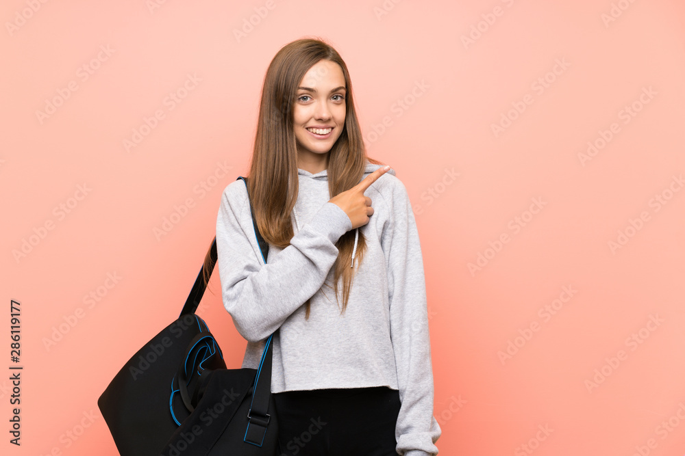 Young sport woman over isolated pink background pointing finger to the side Young sport woman over isolated pink background pointing finger to the side