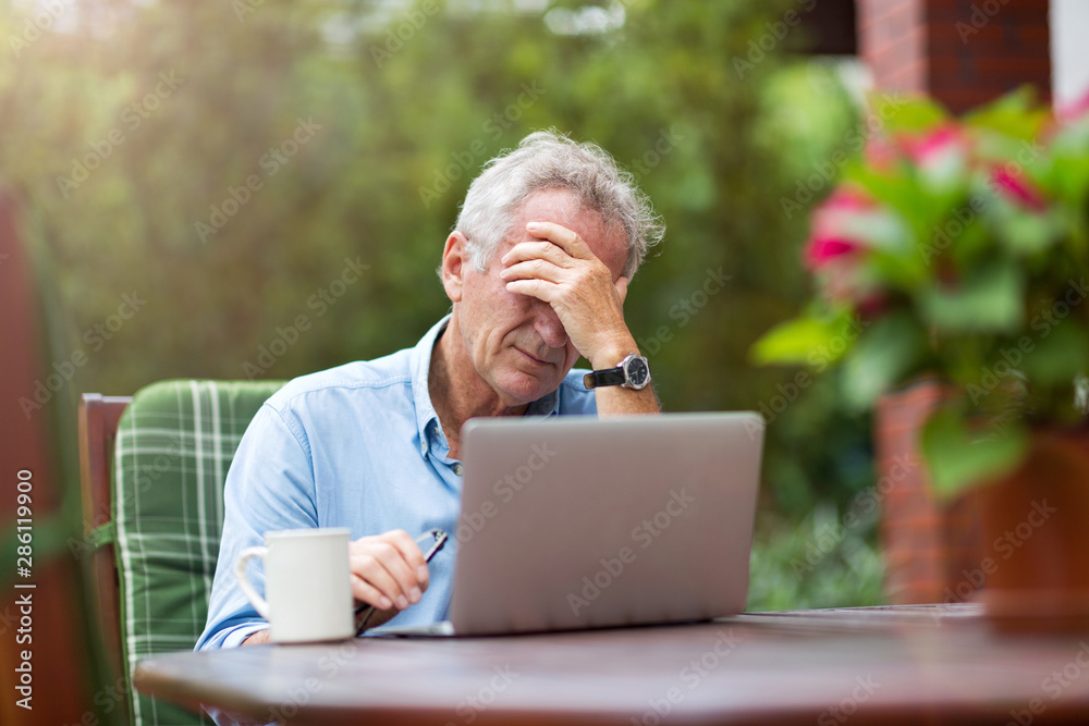 Senior man looking stressed while working on laptop Senior man looking stressed while working on laptop