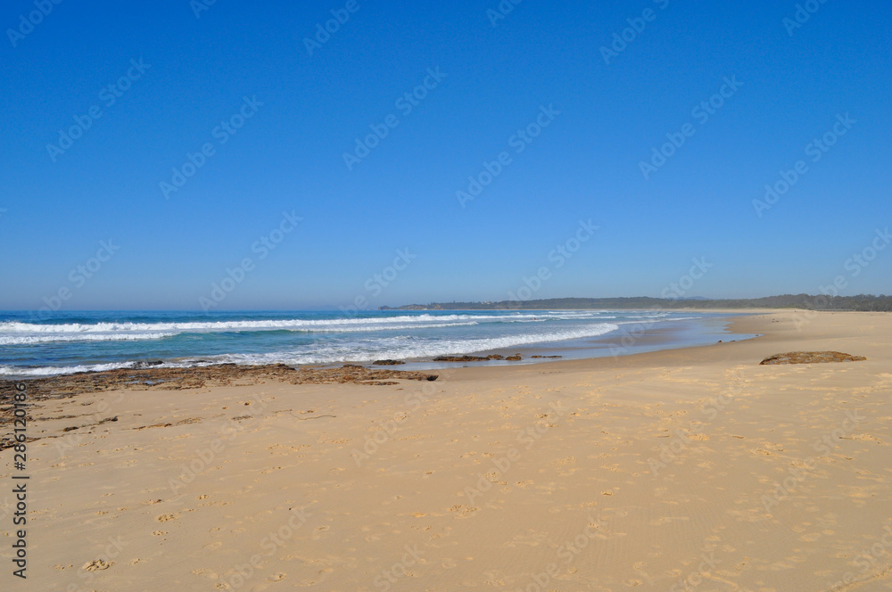 Coastal view of South Valla Beach with surf and clear blue sky, Valla Beach, New South Wales, Australia