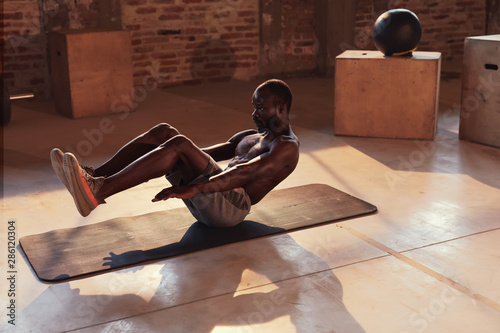 Sport man doing abs exercise workout at gym indoors. Fitness