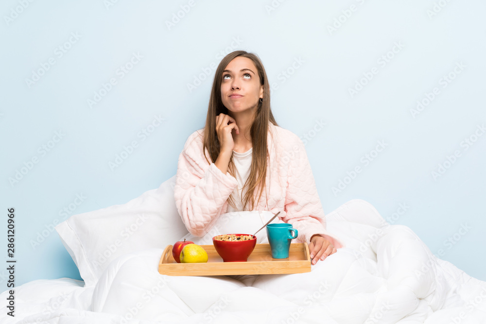Young woman in dressing gown with breakfast thinking an idea
