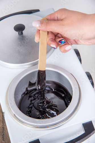 Preparation of wax for shugaring. Close-up wax for depilation is heated and melted in a round container