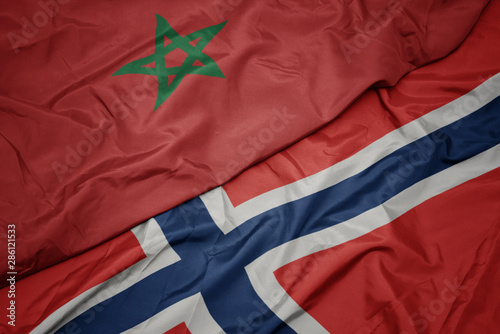 waving colorful flag of norway and national flag of morocco.