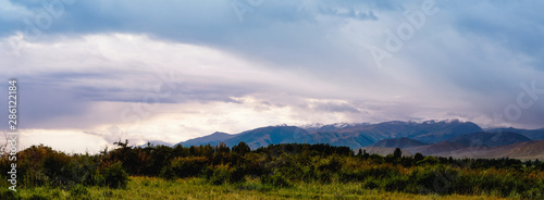 Panorama of a mountain valley in the summer. Amazing nature  mountains lit by sunset  summer in the mountains. Travel  tourism  beautiful background  picture of nature