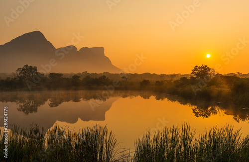 Landscape of the Hanging Lip or Hanglip mountain peak at sunrise with mist hanging above a swamp lake inside the Entabeni Safari Game Reserve, Limpopo Province, South Africa. photo