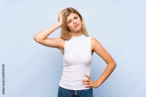 Teenager girl over isolated blue background with toothache