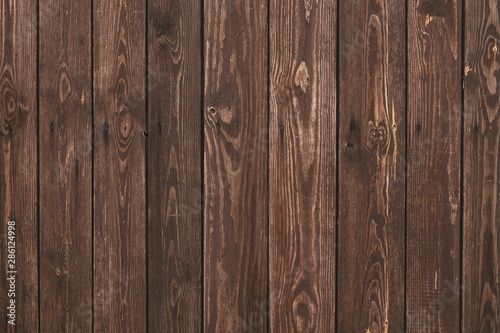 Old shabby wooden fence. Abstract pattern texture background. Brown faded boards. Oak bars, logs. Wood surface. Vertical stripes timber slats. Parallel bars. © tatyana