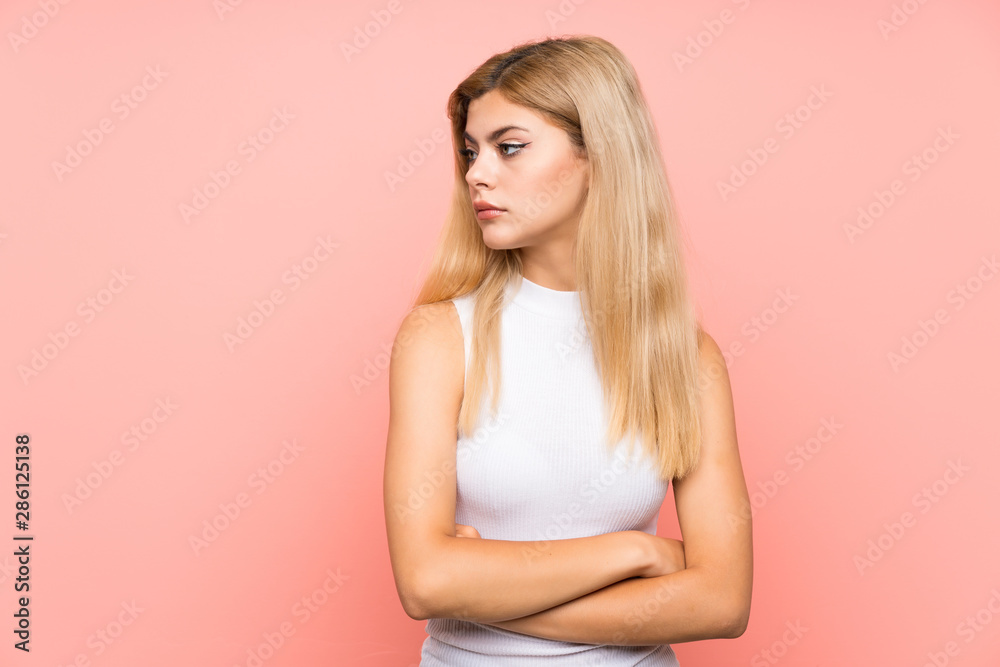 Teenager girl over isolated pink background looking side Teenager girl over isolated pink background looking side