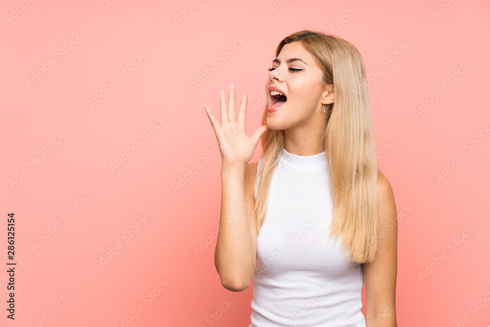 Teenager girl over isolated pink background shouting with mouth wide open Teenager girl over isolated pink background shouting with mouth wide open