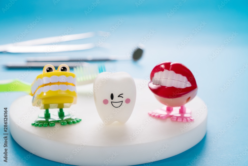 Obraz premium Dental tools and smile teeth model on blue background.