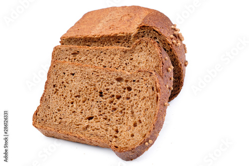 loaf of dark bread partly cut in slices, isolated on white