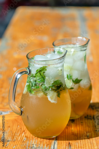 two mugs with mojito on wooden table