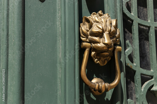 A brass door knocker on an old door in Porto