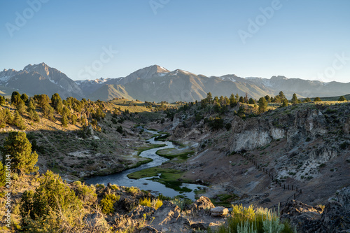 Winding creek of Hot Creek Geological Site in Mammoth Lakes California at dusk sunset, with backlighting. Sierra Nevada mountains in distance photo