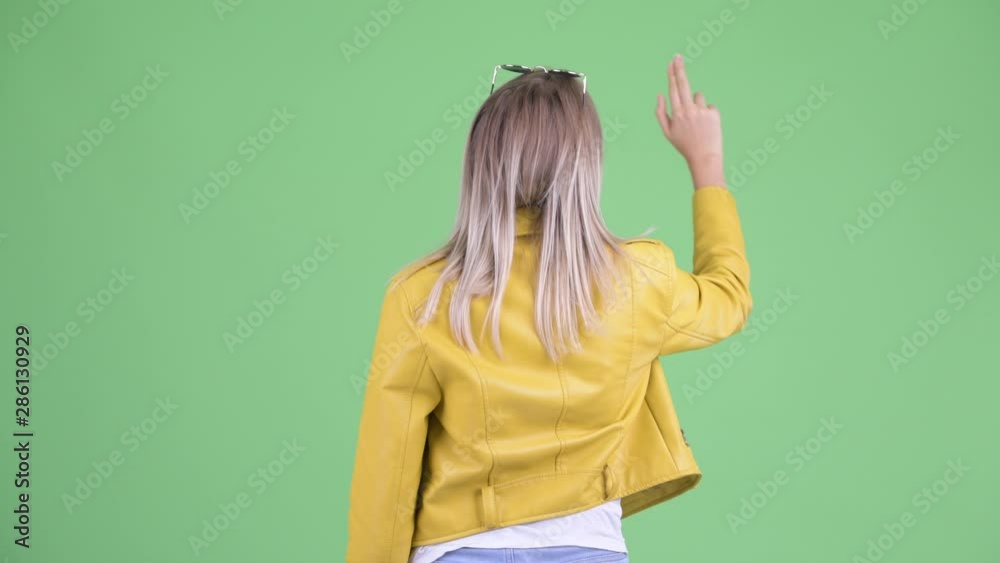 Rear view of young rebellious blonde woman touching something Rear view of young rebellious blonde woman touching something