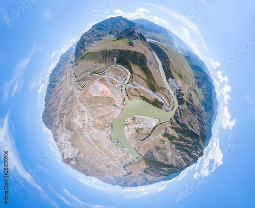 Fototapeta Naklejka Na Ścianę i Meble -  Aerial view of planet earth with the image of nature and picturesque landscapes near a mountain with a river and green trees on a summer day and blue sky. A small and defenseless planet.