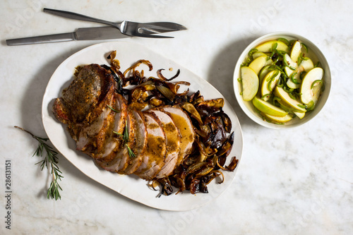 Overhead view of pork loin with apples served on plate