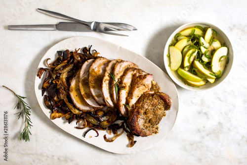 Overhead view of pork loin with apples served on plate