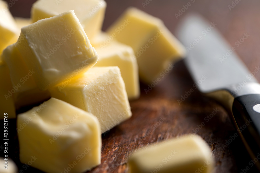 © Andrew Scrivani - Close up of butter cubes and knife on wooden table © Andrew Scrivani - Close up of butter cubes and knife on wooden table