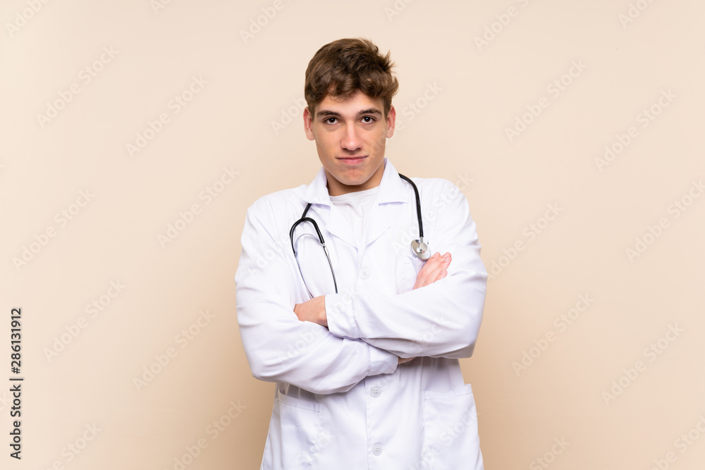 Handsome doctor young man over isolated wall making doubts gesture while lifting the shoulders Handsome doctor young man over isolated wall making doubts gesture while lifting the shoulders