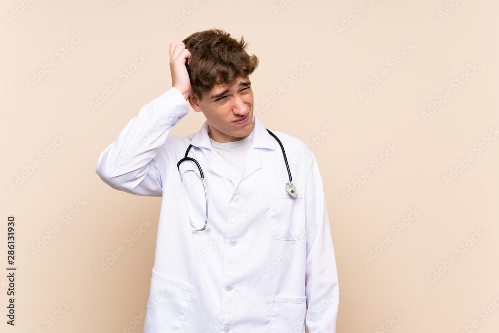 Handsome doctor young man over isolated wall having doubts and with confuse face expression Handsome doctor young man over isolated wall having doubts and with confuse face expression