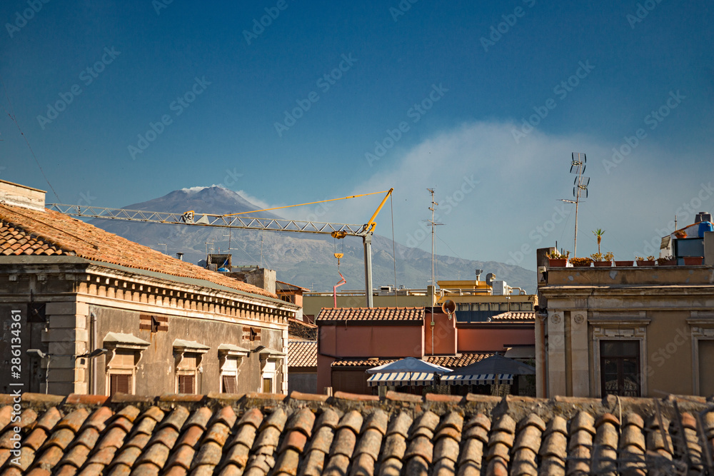 Fototapeta premium Panoramic view of the volcano Etna from the roofs of the historic center of Catania, in Sicily Italy.