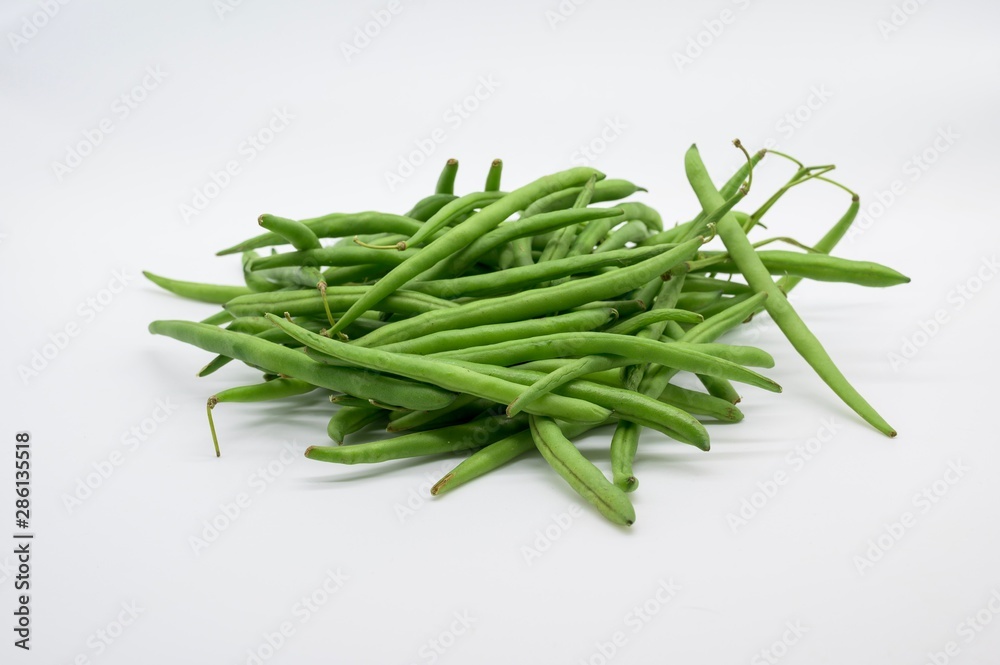 A handful of green beans fresh from the market in front of white background A handful of green beans fresh from the market in front of white background