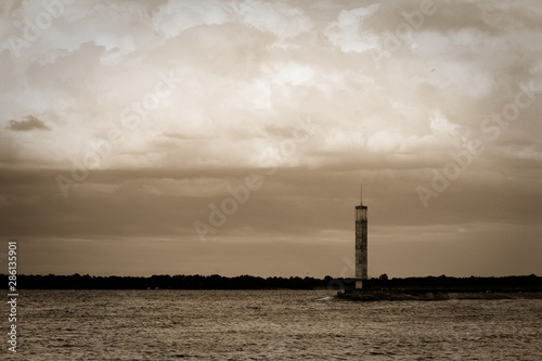 Lighthouse or old beacon under storm clouds