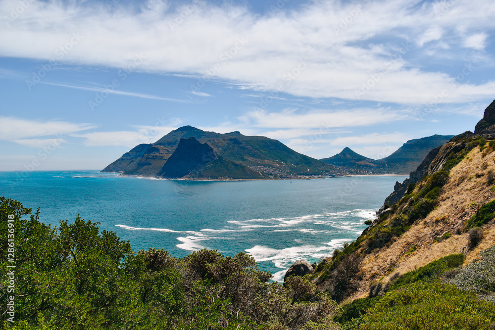 Hout Bay and suurounding mountains against sea and sky on summer day