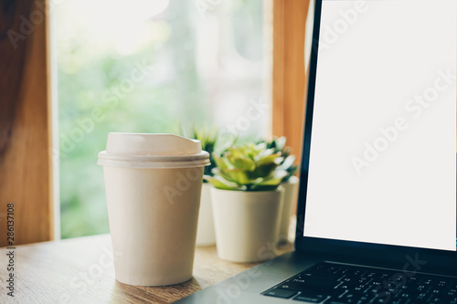 Cropped Image Of coffee and laptop on wooden table