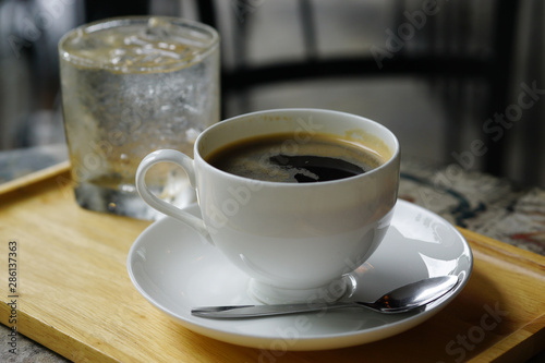 Close Up cup of coffee in a wooden tray on iron table