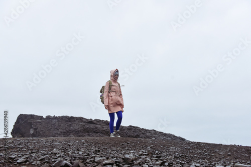 Icelandic black sand beach. Amazing lanscape nature in Iceland. Woman travelling with travel bag