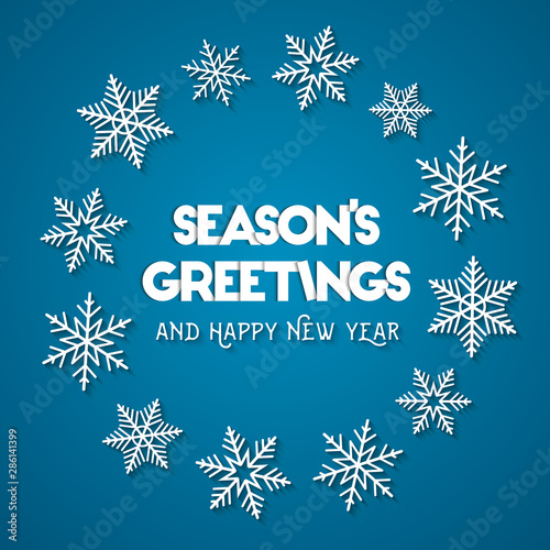 Season's Greetings and Happy New Year concept. Abstract wreath made of white snowflakes on blue background