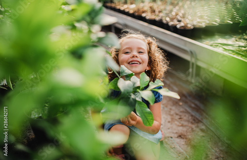 Portrait of small girl standing in the garden center.