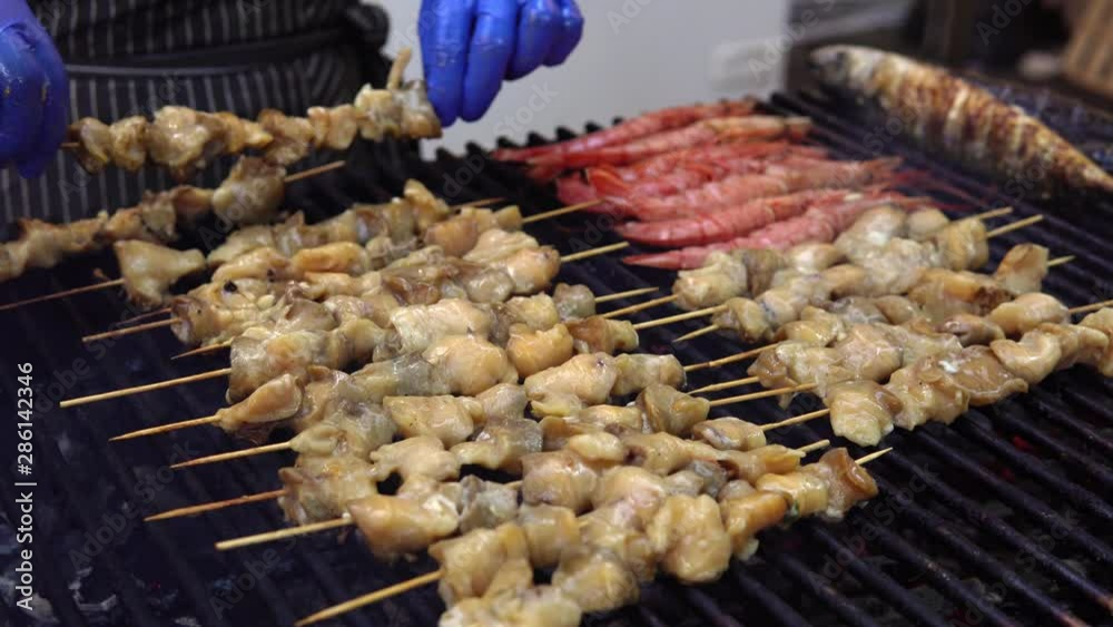 Man cooking sea food on barbecue grill for his friends at summer outdoor party. Cooking sea food on hot charcoal. Man cooking sea food on barbecue grill for his friends at summer outdoor party. Cooking sea food on hot charcoal.